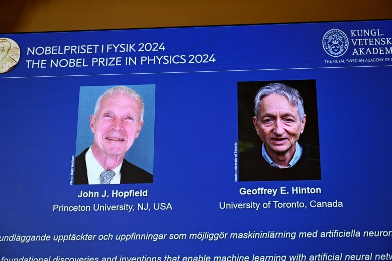 Two elderly men are shown in a video projection in a room during a presentation.